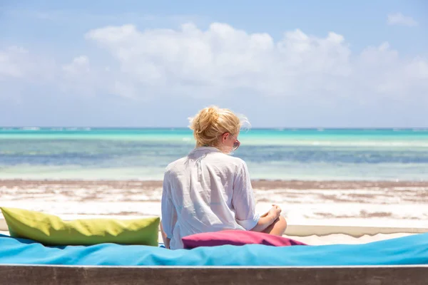Mujer relajada en una tumbona de lujo, brazos levantados, disfrutando de las vacaciones de verano en la hermosa playa . —  Fotos de Stock