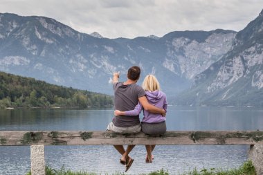 Kucakladı çift sakin izlerken bulutlu sabah olay yerinde göl Bohinj, Alp Dağları, Slovenya.