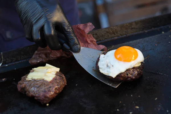 Szakács, így marha hamburgerek kültéri nyitott konyha nemzetközi élelmiszer-fesztivál rendezvény. — Stock Fotó