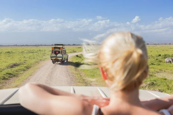 Frau auf afrikanischer Wildtiersafari beobachtet Natur aus offenem Dach Safari Jeep. — Stockfoto