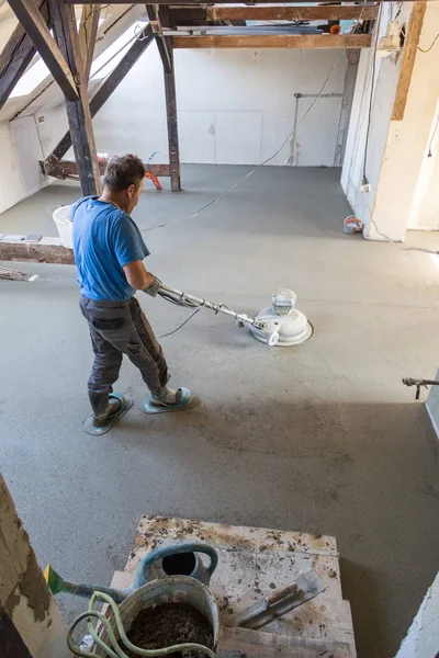 Trabalhador polimento areia e betonilha de cimento piso. — Fotografia de Stock