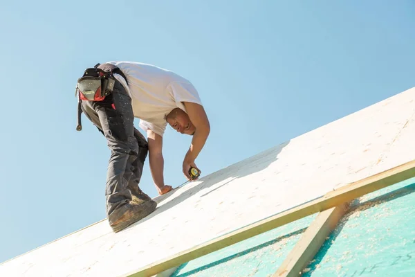 Construtor no trabalho com construção de telhado de madeira. — Fotografia de Stock
