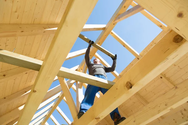 Constructor en el trabajo con la construcción de techos de madera. — Foto de Stock