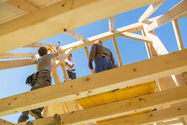 Builders at work with wooden roof construction. — Stock Photo, Image