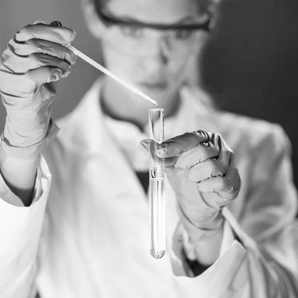 Jovem cientista pipetando em laboratório de ciências da vida. — Fotografia de Stock