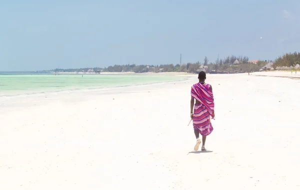 Guerrero masai caminando en la perfecta playa de arena tropical. Paje, Zanzíbar, Tanzania . — Foto de Stock