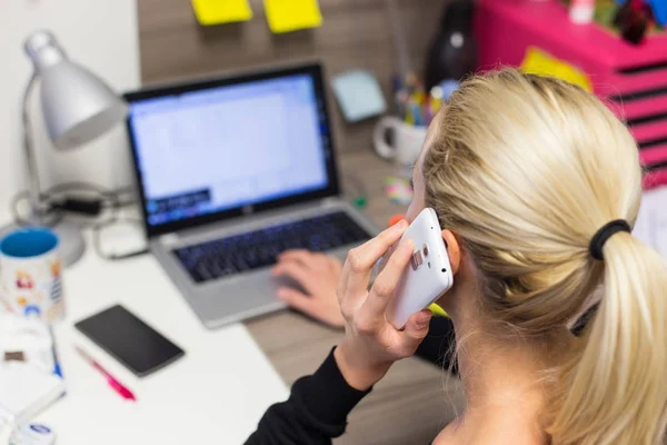 Žena podnikatel mluví na mobilním telefonu v barevném moderním kreativním pracovním prostředí. — Stock fotografie