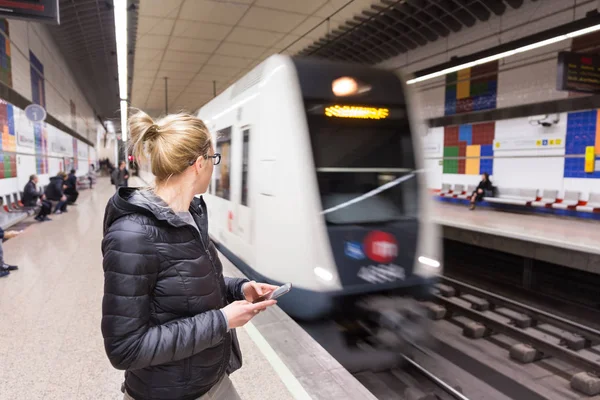 Femme avec un téléphone portable attendant le métro . — Photo