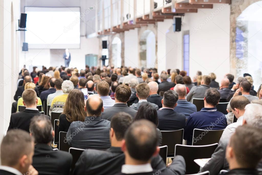 Business speaker giving a talk at business conference event.