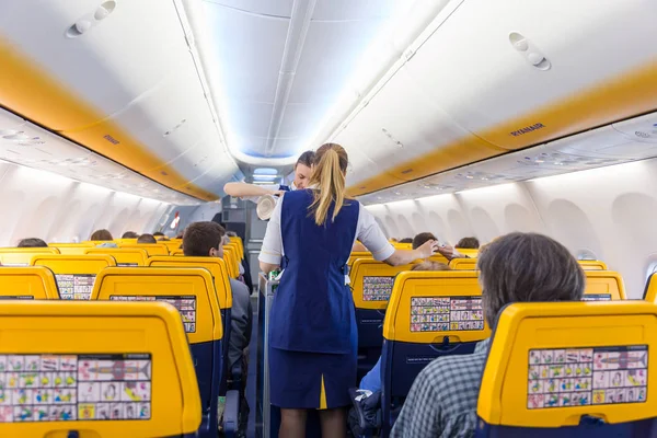 Stewardess serving passangers on Ryanair airplane flight on 14th of December, 2017 on a flight from Trieste to Valencia. — Stock Photo, Image