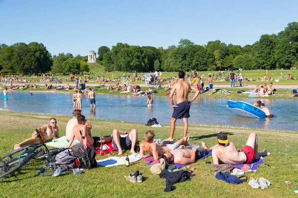Lidé se těší letní den v městském parku Englischer Garten v Mnichově, Německo. — Stock fotografie