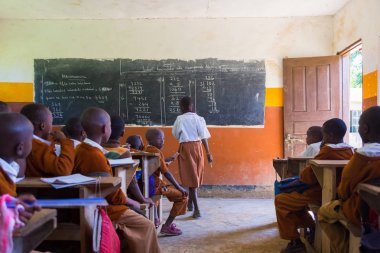 Çocuklar İlköğretim Okulu sınıf listetning öğretmeni Arusha, Tanzanya, Afrika yakınlarındaki kırsal alanda üniformalı.