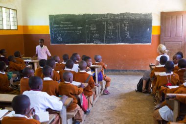 Çocuklar İlköğretim Okulu sınıf listetning öğretmeni Arusha, Tanzanya, Afrika yakınlarındaki kırsal alanda üniformalı.