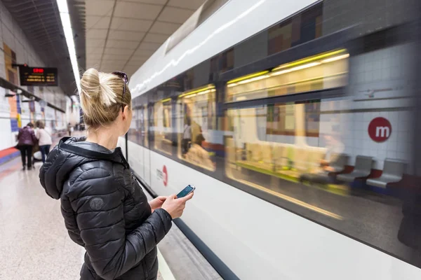 Femme avec un téléphone portable attendant le métro . — Photo