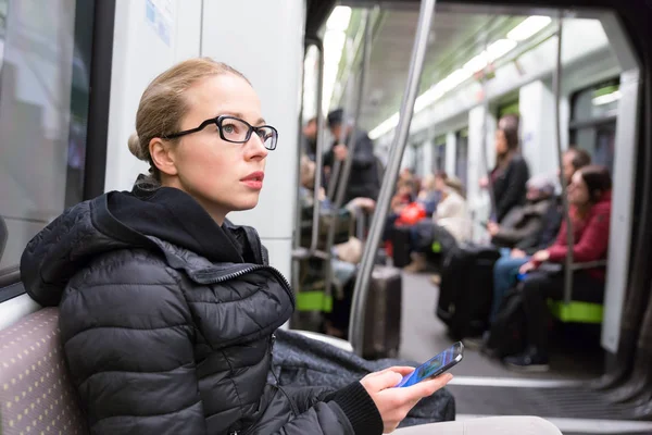 Menina com telefone celular viajando no metrô . — Fotografia de Stock