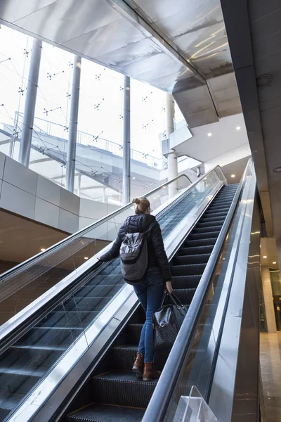 Affärskvinna med stor svart väska och mobiltelefon stigande på rulltrappan. — Stockfoto