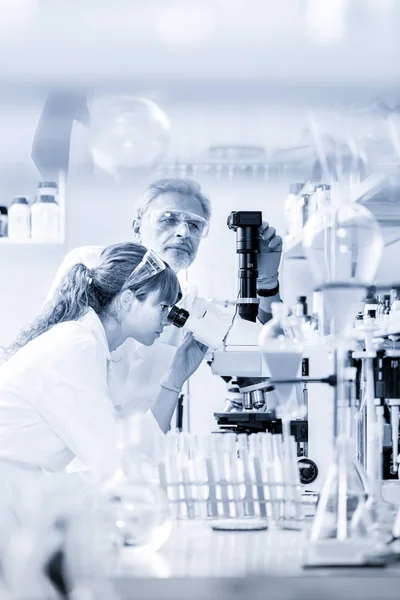 Ricercatori sanitari al microscopio in laboratorio scientifico . — Foto Stock