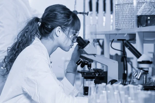Microscopio di ricercatrice sanitaria femminile in laboratorio scientifico . — Foto Stock