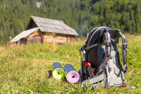 Rucksack und Yogamatten auf der Bergwiese. — Stockfoto
