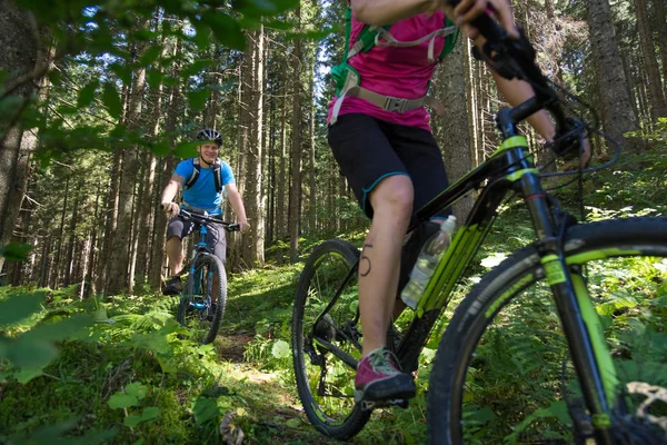 Active sporty couple riding mountain bikes on forest trail . — Stock Photo, Image