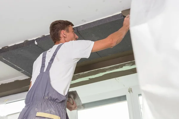Murare renovera inomhus väggar och tak. Avslutande arbeten. — Stockfoto