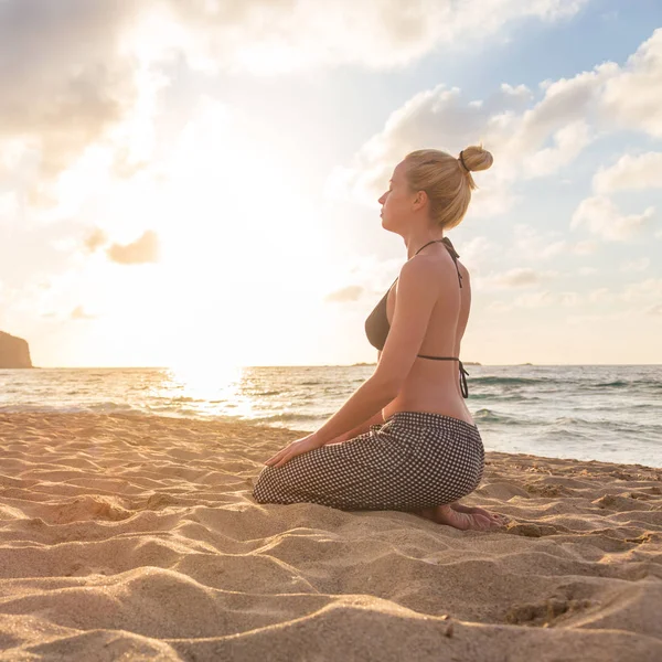 Vrouw ontspannen aan zee strand bij zonsondergang. — Stockfoto