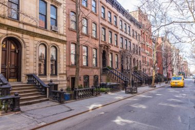 Manhattan New York'ta, Nyc ABD West Village Mahallesi'nde tarihi kumtaşı binaların doğal ağaç sokak