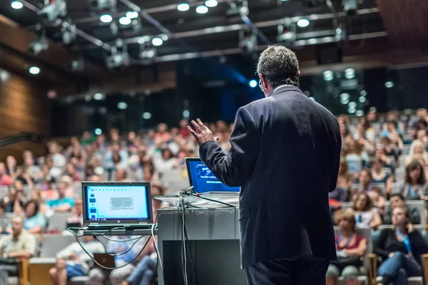 Public speaker giving talk at Business Event.