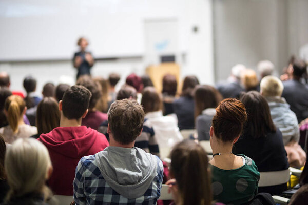 Woman giving presentation in lecture hall at university.