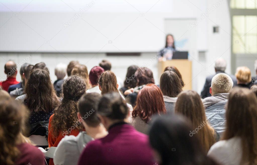 Woman giving presentation in lecture hall at university.