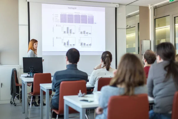 Vrouw geeft presentatie in collegezaal op de universiteit. — Stockfoto