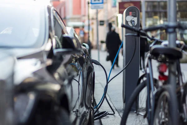 Зарядка сучасного електромобіля на вулиці як майбутнє автомобільної промисловості . — стокове фото