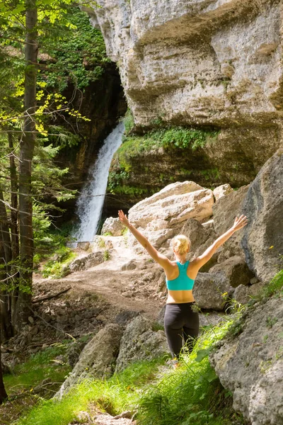 Active woman raising arms inhaling fresh air, feeling relaxed in nature. — Stock Photo, Image
