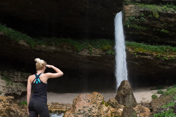 Actieve vrouw kijken naar Pericnik waterval in Vrata vallei in Triglav Nationaal Park Julische Alpen, Slovenië. — Stockfoto