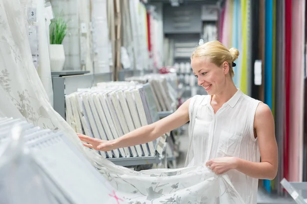 Hermosa ama de casa comprar cortinas blancas en la tienda de muebles de decoración del hogar . — Foto de Stock