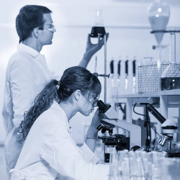 Zorgverleners microscoping in wetenschappelijke laboratorium. — Stockfoto