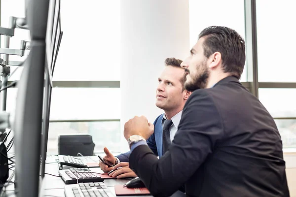 Aktiehandlare som tittar på marknadsdata på datorskärmar. — Stockfoto