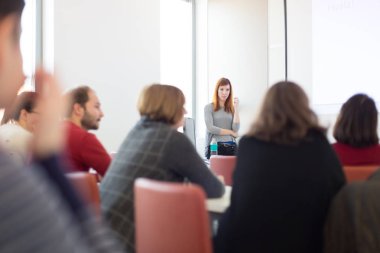 Üniversitedeki konferans salonunda sunum yapan kadın..