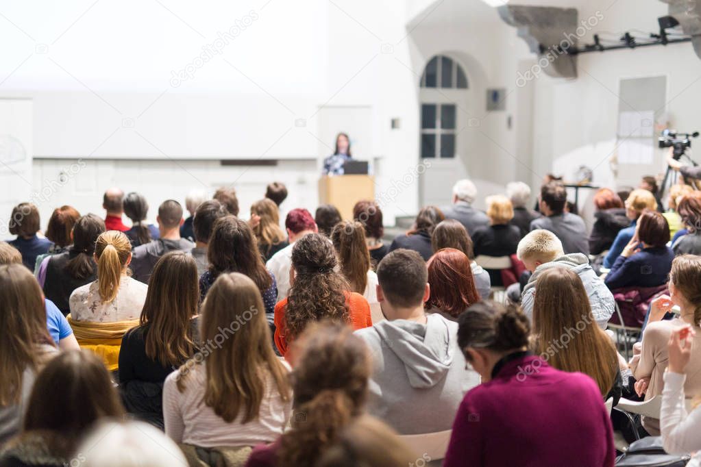 Woman giving presentation in lecture hall at university.