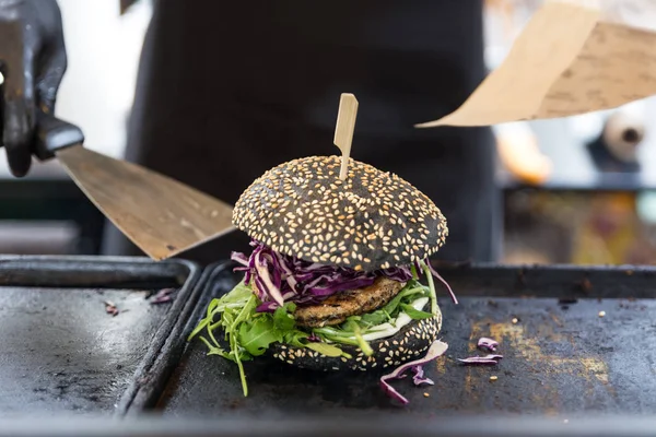 Chef preparando hamburguesas en el plato de parrilla en el festival internacional de comida urbana callejera . —  Fotos de Stock