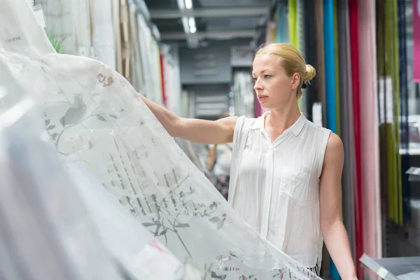 Hermosa ama de casa comprar cortinas blancas en la tienda de muebles de decoración del hogar . — Foto de Stock