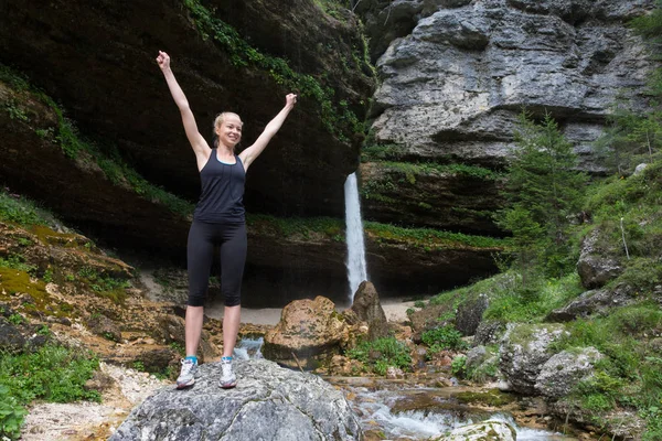 Mujer activa levantando brazos inhalando aire fresco, sintiéndose relajada en la naturaleza . —  Fotos de Stock