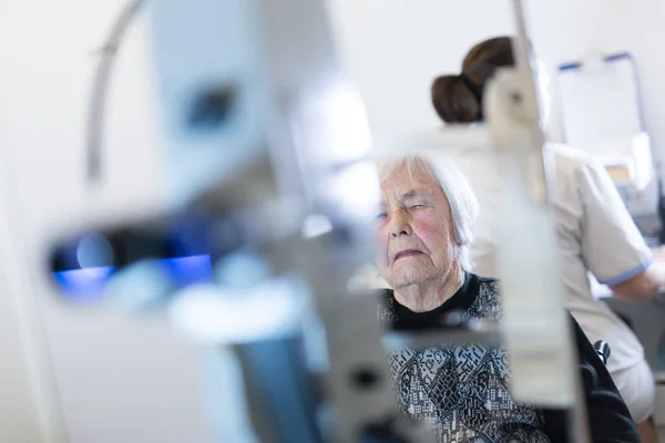 Senior vrouw beeing prepered voor laserchirurgie in kliniek voor oogheelkunde. — Stockfoto