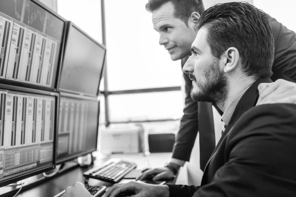 Aandelenhandelaren die marktgegevens op computerschermen bekijken. — Stockfoto