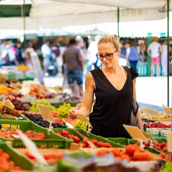 Mulher comprando frutas e legumes no mercado local de alimentos. Barraca de mercado com variedade de vegetais orgânicos — Fotografia de Stock