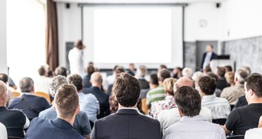 Benim bir sorum var. Bir grup iş adamı konferans salonunda oturuyor. İş adamı kolunu kaldırıyor. Konferans ve Sunum. İş ve Girişimcilik