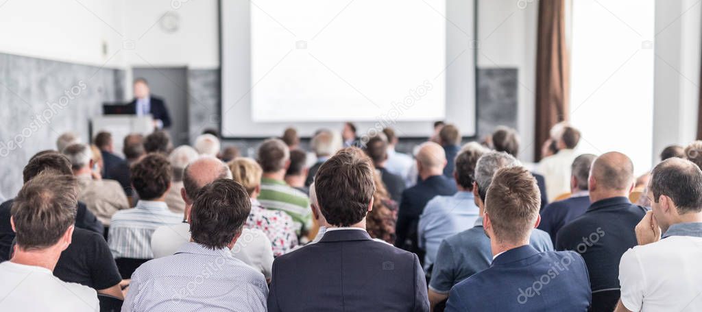 Business speaker giving a talk at business conference event.