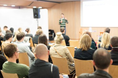 üniversitede konferans salonunda sunum yapan konuşmacı