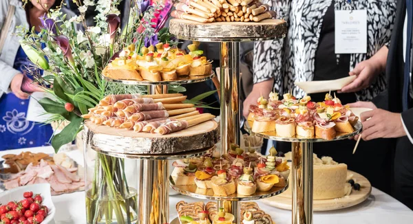 Empresários na pausa para o almoço do banquete na conferência de negócios. Sortimento de canapés e comida para os dedos na mesa. — Fotografia de Stock