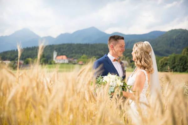 Serrer tendrement la mariée dans un champ de blé quelque part dans la campagne slovène . — Photo